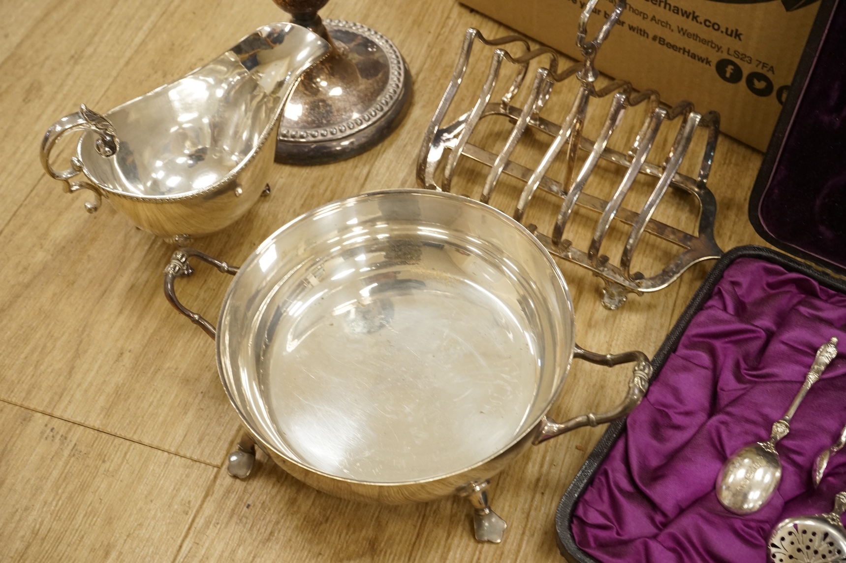 A quantity of assorted plated wares, including flatware, a tea caddy, a chatelaine, a toast rack, a sauceboat, a butter dish and a pair of candlesticks, etc.